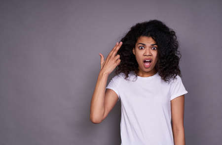 Photo grimace funky funny stylish trendy cheerful black youth expressing joy with her face, emotional indication of an object for purchase isolated on gray bright background.の写真素材
