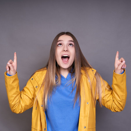 A good looking blonde female with clean healthy skin looks in amazement as she points something up,...