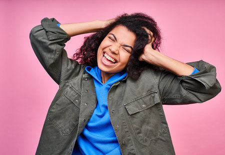 Funny young African-American woman, holds his hand head, closed her eyes. A young dark girl shows...