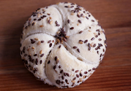 Tasty freshly baked butter kaiser with linseed and sunflower seeds. Top view, copy space, selective...