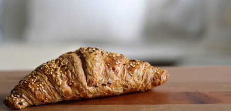 Breakfast with fresh croissant on wooden table.Blurred background.