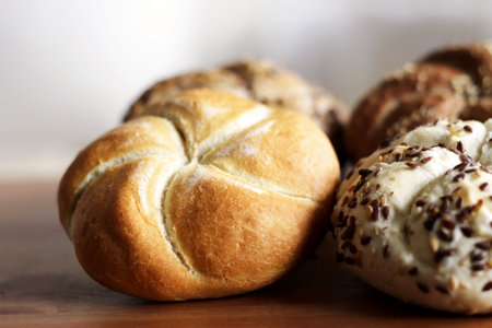Tasty freshly baked butter kaiser roll with linseed and sunflower seeds. Top view, copy space,...