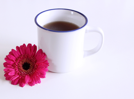 Gerbera flower and a hot cup of tea on wooden table. Seasonal, morning tea, Sunday relax and still life concept. Free place for text.Food concept.の写真素材