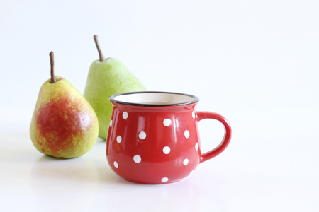 Fresh pear juice in a red mug and fresh pears fruits on a white table. Healthy drink .Breakfast concept.の写真素材