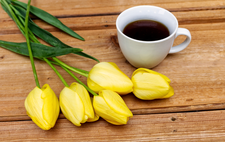 Styled stock photo. Spring feminine scene, floral composition. Bunch of beautiful tulips and coffee on the wooden table.の写真素材