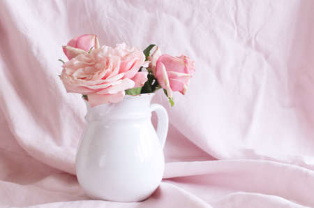 Spring, summer still life scene. Vintage wedding feminine styled photo, floral composition. Bouquet of pink roses in a white vase.の写真素材