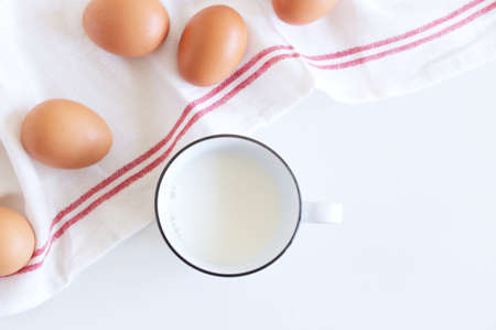 Spring breakfast still life scene with chicken eggs, a cup of milk, and a tea towel. Easter food and drink concept. Farmhouse, Scandinavian design. Food concept.の写真素材