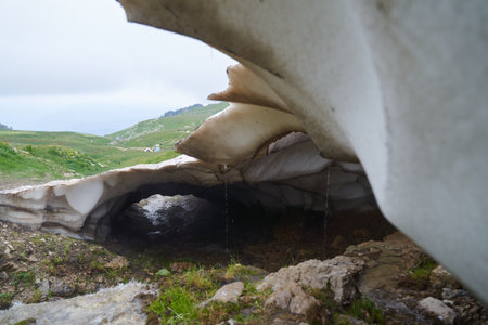 Close-up of a glacier melting in the mountains, washed away by stream.の写真素材