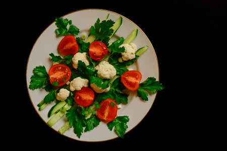 Fresh vegetables salad with white cabbage on black background. Top viewの写真素材
