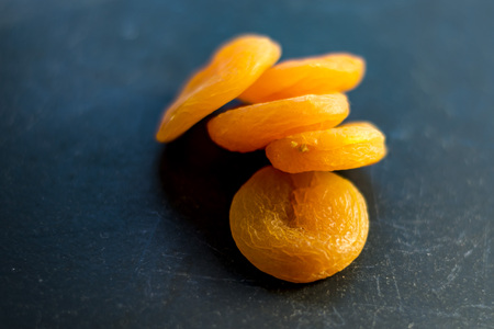 Dried apricots, top view, macro. Closeup of yellow dried fruit, black background.の写真素材