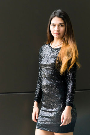 Portrait of an attractive young woman in black dress. Outdoor portrait of a beautiful woman in black...