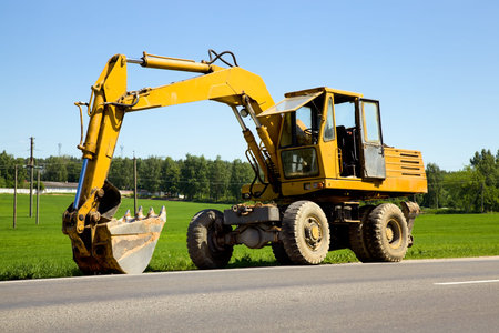 tractor with bucket, standing on the edge of the road
