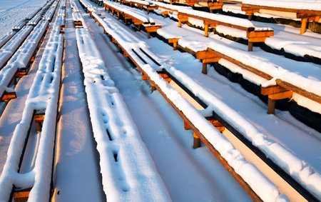 the old wooden benches covered with snow. old stadium, Belarusの写真素材