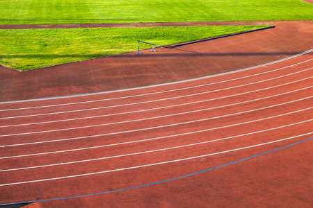 red running track divided by the band. The stadiumの写真素材