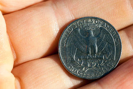 photographed close-up of a quarter of the US dollar in the hands of a man,の写真素材