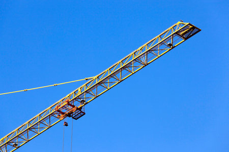 photographed close-up construction cranes during construction of a new multi-storey residential...