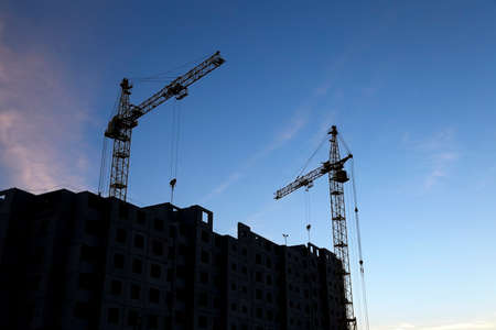 photographed close-up construction cranes during construction of a new multi-storey residential buildingの写真素材
