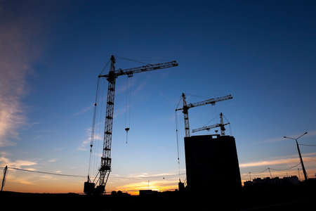 photographed close-up construction cranes during construction of a new multi-storey residential buildingの写真素材