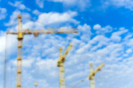 photographed close-up construction cranes during construction of a new multi-storey apartment building, blue sky, defocusの写真素材