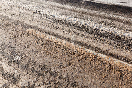 dirty snow and slush on the asphalt road. winter time of the year. photo close upの写真素材