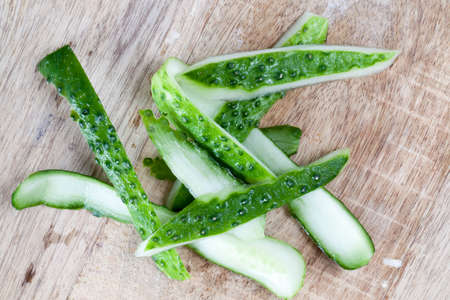 Peel from the ripe green cucumber lying on a wooden surface. close-upの写真素材
