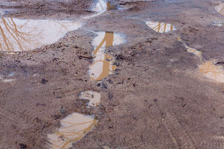 rural road of poor quality - off-road. Surface with pits filled with water after the last rainの写真素材