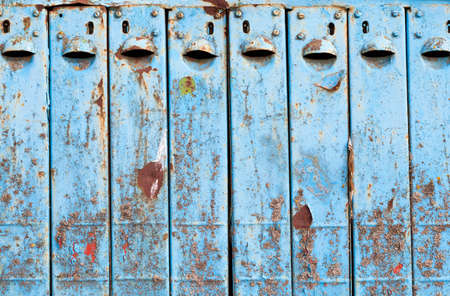 Old blue mailbox for several houses. The box is made of metal and painted with blue paint. Iron began to rust and paintの写真素材