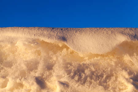 lying on the ground of snow drifts after a blizzard. Photo close-up in winter.の写真素材