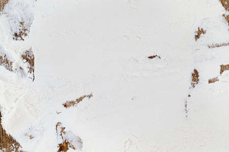 White flour scattered on a wooden table while making bread and bakingの写真素材