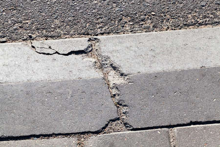 broken concrete curb near the roadway. photo close-up in the cityの写真素材