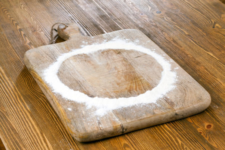 Poured flour on a wooden cutting board in the form of a circle. Photo close upの写真素材