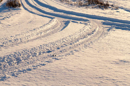 snow remaining on the track after a passing car. Photo close-up from top to bottom. Small depth of field. Winter seasonの写真素材