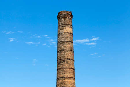 a close-up photo of a pipe from a stove made of bricks. blue skyの写真素材