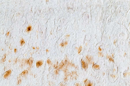 texture of white wheat lavash with yellow spots. photo close upの写真素材