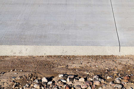 edge of a new road under construction from concrete. photo close-up at an angle. on the edge of the road sand and stones to continue constructionの写真素材