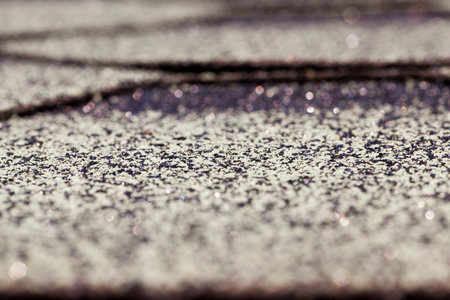 Old flexible tile roof of the house. Small depth of field. The surface of the tile has an inhomogeneous structureの写真素材