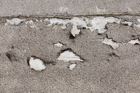 concrete wall of the building with which the plaster is showered. photo close-up of the place of...