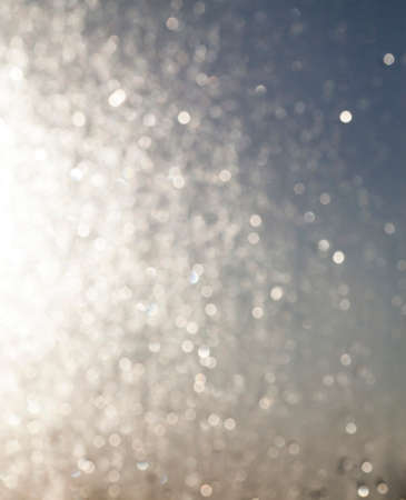 abstract background, photographed close-up. Out of focus, defocus. Photo glass with drops of water during sun dawnの写真素材