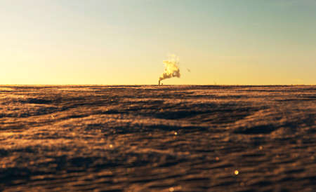 smoke from the work of the enterprise in the winter season. Photo taken at sunset. Yellow tint in the pictureの写真素材