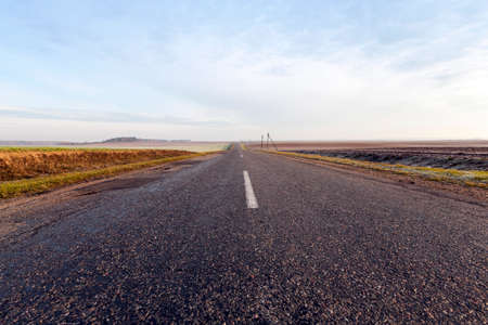 small road covered with asphalt. Photo close-up in summer. Blue sky in the backgroundの写真素材