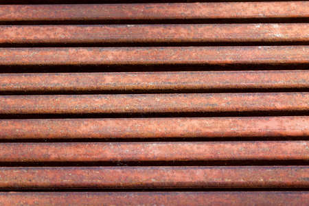 old rusty metal grate of the sewage system. photo close-up of part of a structure, top view. Dark holes.の写真素材