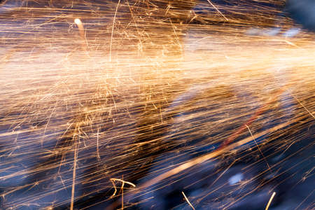 Orange sparks generated when working with metal objects. Photo taken closeup.の写真素材