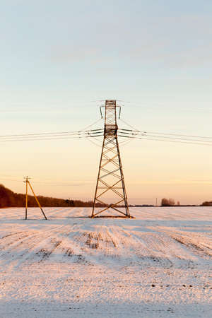 the line of high-voltage gear in the winter season. Photo taken at sunsetの写真素材