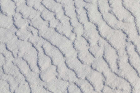 agricultural field, covered with snow in the winter season. On the surface there are irregularities and lines in the snowの写真素材