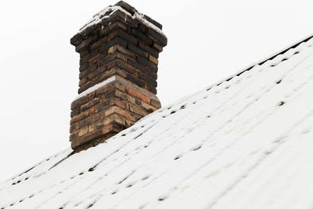 photograph of the roof of a house made of slate covered with snow falling during a snowfallの写真素材