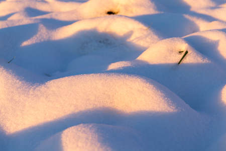 photographed large irregularities in the snow, snowdrifts in the winter season. Time is the sunsetの写真素材
