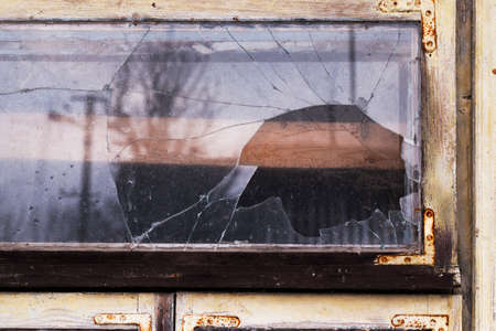 close-up shot of a broken glass in a window of an old wooden houseの写真素材