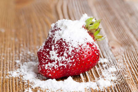 a ripe red strawberry sprinkled with white sugar powder. close-up photoの写真素材