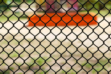 made of metal mesh fence enclosing the territory. photo close-up, summer time of yearの写真素材
