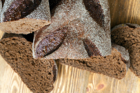 freshly cut homemade rye bread on a wooden cutting board, close-up, top view